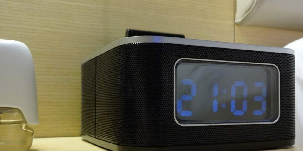 an alarm clock on a nightstand with a camera