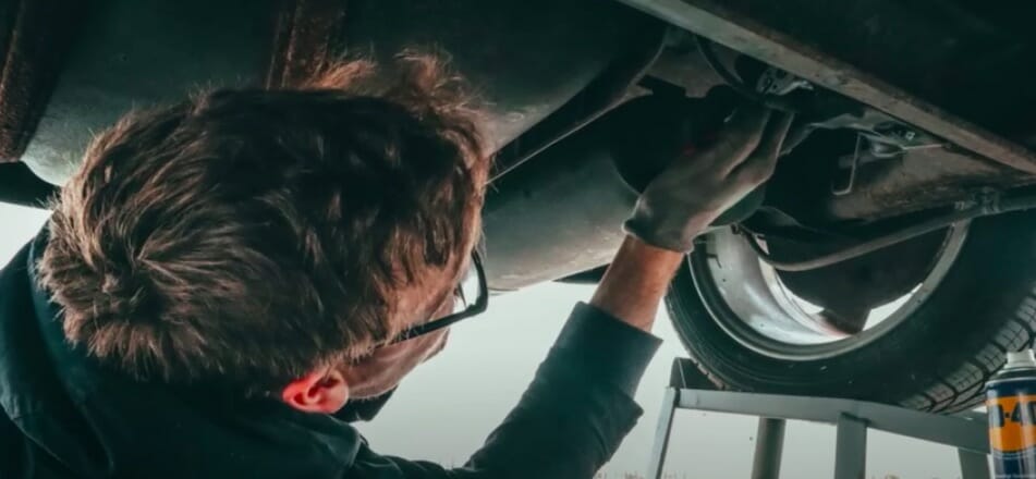 mechanic checking car for gps tracker